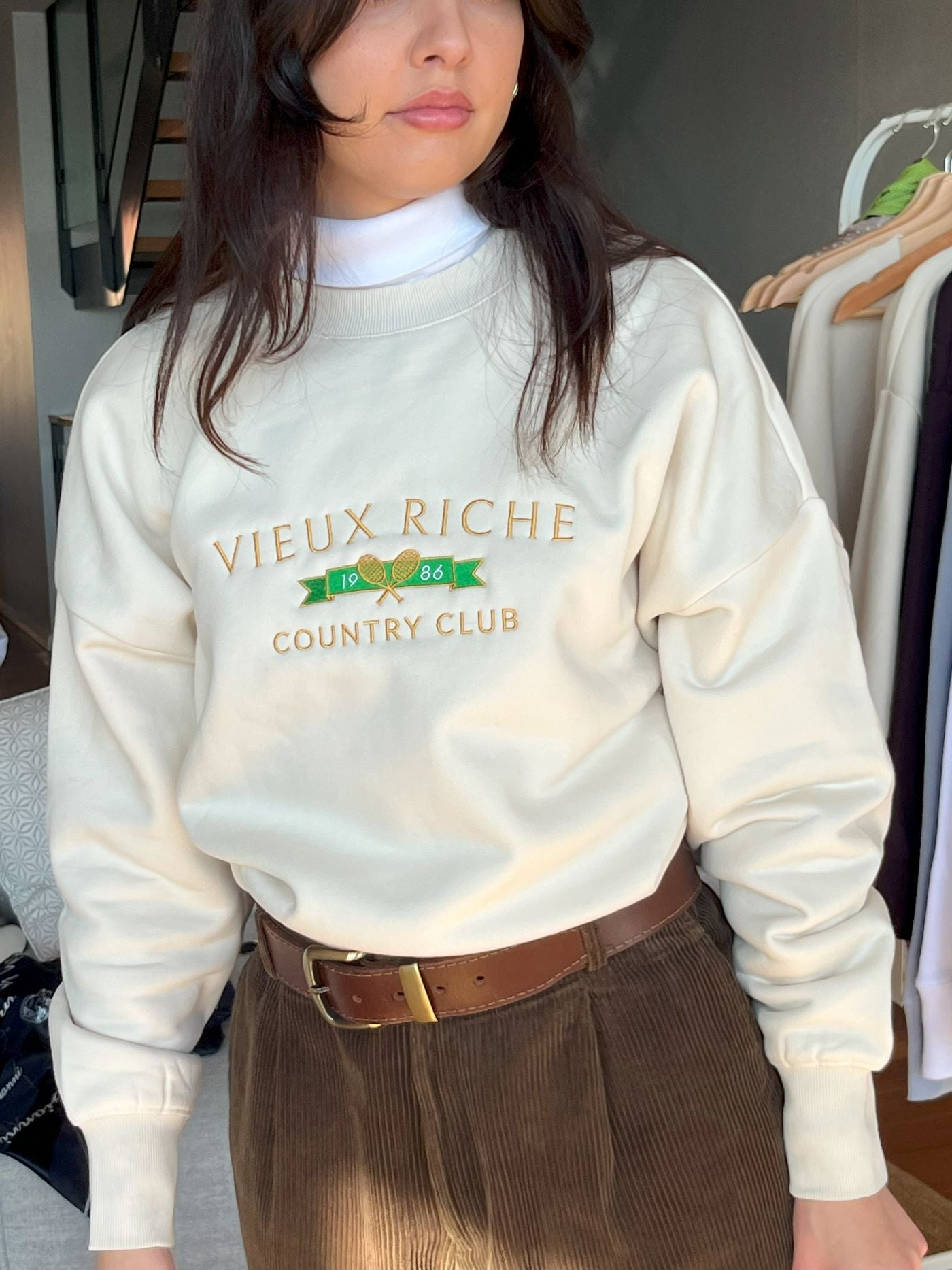 Woman wearing Vieux Riche Vintage Country Club crew neck sweatshirt, The Duchess, with brown corduroy trousers, embodying the old money aesthetic.